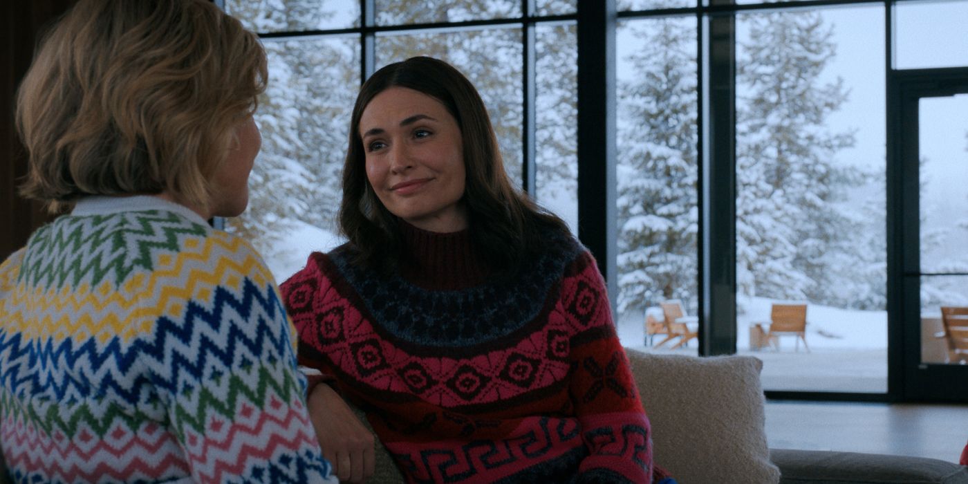 A hive member smiling warmly at Carol in a quiet living room in front of snowy windows