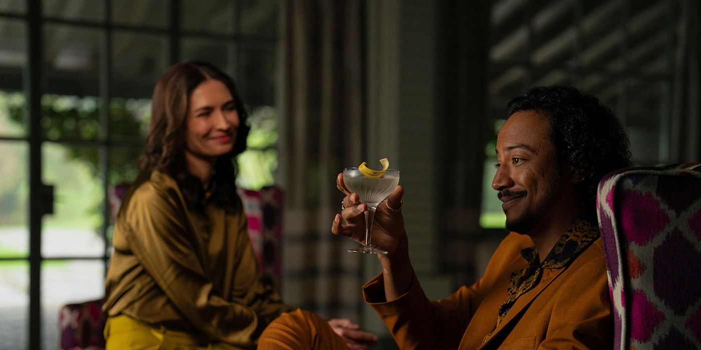 Two hive members clinking martini glasses, both smiling in contented agreement